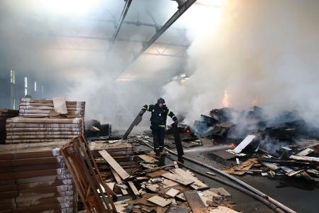 Rettungskräfte löschen in Saporischschja (Ukraine) einen Brand in einer Möbelfabrik, die durch einen russischen Drohnenangriff beschädigt wurde.