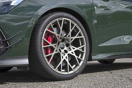 Die Detailaufnahme zeigt das Vorderrad eines Audi RS3 Competition Limited. Hinter der filigranen Mehrspeichenfelge sitzt eine groß dimensionierte Bremsanlage mit rotem Audi‑ceramic‑Bremssattel und gelochter Bremsscheibe; montiert ist ein Pirelli P Zero Sportreifen. Die Perspektive betont zudem die sportlichen Aerodynamik-Elemente am Stoßfänger aus Carbon.
