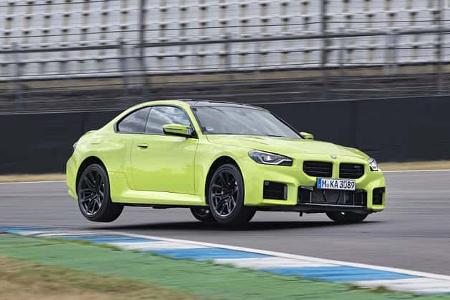 Das Foto zeigt ein BMW M2 Coupe auf der Rennstrecke, aufgenommen in Hockenheim. Das leuchtend grüne Zweitürer-Sportcoupé wird in dynamischer Kurvenfahrt über den Kerb gezeigt; M-spezifische Front mit großen Lufteinlässen, schwarze Akzente und Sportfahrwerk sind gut erkennbar.