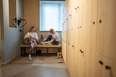 Zwei Frauen unterhalten sich in der Umkleidekabine einer Turnhalle