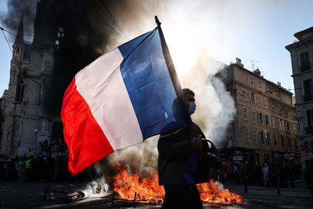 Protesttag in Frankreich: Französische Flagge und Flammen im Protest gegen hohe Lebenshaltungskosten in Marseille