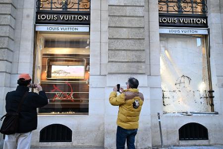 Tag nach Ausschreitungen in Frankreich: Passanten fotografieren Graffiti an Louis Vuitton Geschäft