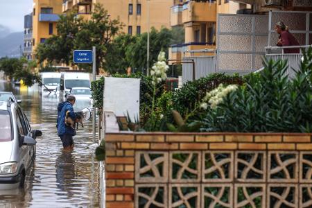 Mann mit Hund im Hochwasser: Starkregen überflutet Valencia