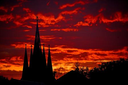 Die Türme der protestantischen Kirche von Teglaskert in in Ungarn zeichnen sich vor der untergehenden Sonne ab.