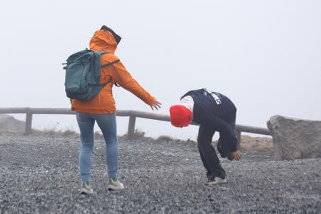 Wanderer auf dem Brocken kämpfen gegen starke Windböen an.