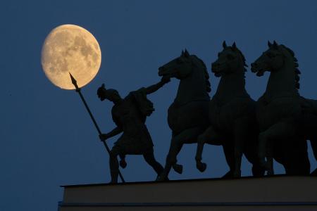 Der Mond geht über einer Streitwagenstatue auf dem Dach des Generalstabs-Hauptquartiers in St. Petersburg auf.
