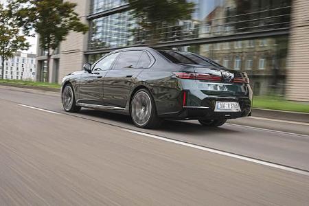Das Foto zeigt einen BMW 740 xDrive als viertürige Oberklasse‑Limousine in Heck‑/Seitenansicht. Sichtbar sind der xDrive‑Allradantriebstyp, flächige LED‑Rückleuchten, die lange Karosserie und großformatige Leichtmetallräder. Die Aufnahme zeigt das Fahrzeug in Fahrt auf einer Stadtstraße (IPTC: Stadt).