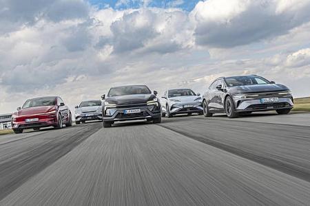 Fünf Elektro-Modelle – BYD Sealion 7 EXcellence AWD, Kia EV 6 GT AWD, Polestar 4 Dual Motor, Tesla Model Y Performance und Zeekr 7GT AWD – fahren im Verbund frontal auf einer Teststrecke. Die Frontansicht in leichter Untersicht zeigt die Fahrzeuge bei zügiger Geradeausfahrt; alle sind als Allrad- bzw. Performance-Varianten gekennzeichnet. Der offene Himmel und die abgesperrte Strecke deuten auf ein Vergleichstest-Setup hin.