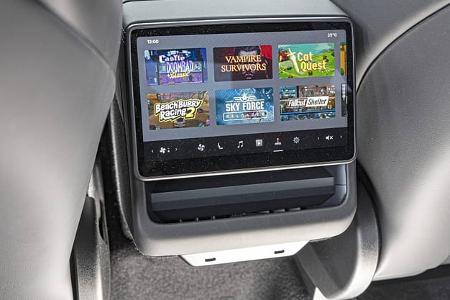 Die Aufnahme zeigt das Rücksitz‑Touchdisplay eines Tesla Model Y Performance. Auf dem zentralen Fondbildschirm ist Tesla Arcade mit mehreren Spieltiteln zu sehen; darunter liegen ein Ablagefach und zwei USB‑C‑Anschlüsse an der Rückseite der Mittelkonsole. Die Aufnahme datiert vom 16.09.2026 laut Dateiname.