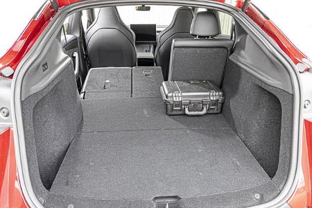 Das Foto zeigt den Kofferraum eines Tesla Model Y Performance mit geöffneter Heckklappe. Ein Teil der geteilten Rücksitzlehnen ist umgeklappt und bildet mit dem Ladeboden eine nahezu ebene Fläche; rechts liegt ein kleiner Hartschalenkoffer als Größenreferenz. Laut Dateiname stammt die Aufnahme vom 16.09.2026.