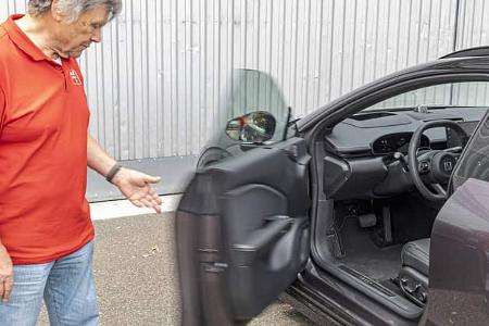 Das Foto zeigt einen Zeekr 7GT AWD mit geöffneter Fahrertür; der Blick fällt auf Lenkrad, Instrumente und Pedalerie. Die Aufnahme betont den Innenraumbereich und den Türöffnungsprozess, erkennbar an der Bewegungsunschärfe der Tür, während eine Person daneben steht. Die Bezeichnung AWD weist auf Allradantrieb hin.