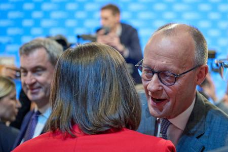 Friedrich Merz begrüßt Ilse Aigner mit Wangenküsschen.
