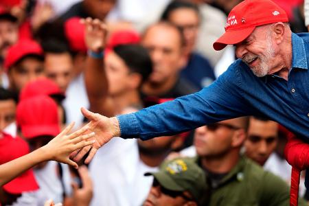 Der brasilianische Präsident Luiz Inácio Lula da Silva, der sich um eine Wiederwahl bewirbt, begrüßt einen Anhänger während seiner letzten Wahlkampfveranstaltung in São Paulo einen Tag vor der Stichwahl um das Präsidentenamt.