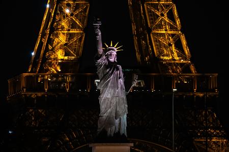 Eine Nachbildung der Freiheitsstatue steht vor dem Eiffelturm in Paris.