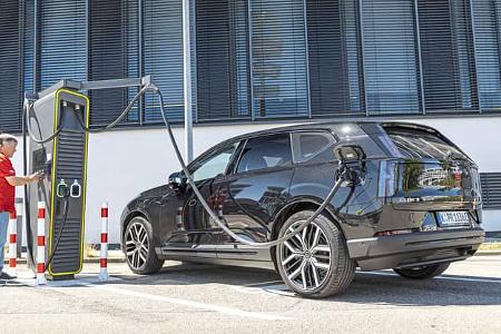 Das Foto zeigt einen Volvo EX60 P10 AWD beim Laden an einer öffentlichen Schnellladesäule. Der vollelektrische Allrad‑SUV ist seitlich in einer Parkbucht zu sehen; das dicke DC‑Ladekabel ist am Fahrzeug angeschlossen und die Ladesäule mit Display steht links im Bild. Die Aufnahme stammt laut Dateiname aus August 2026.